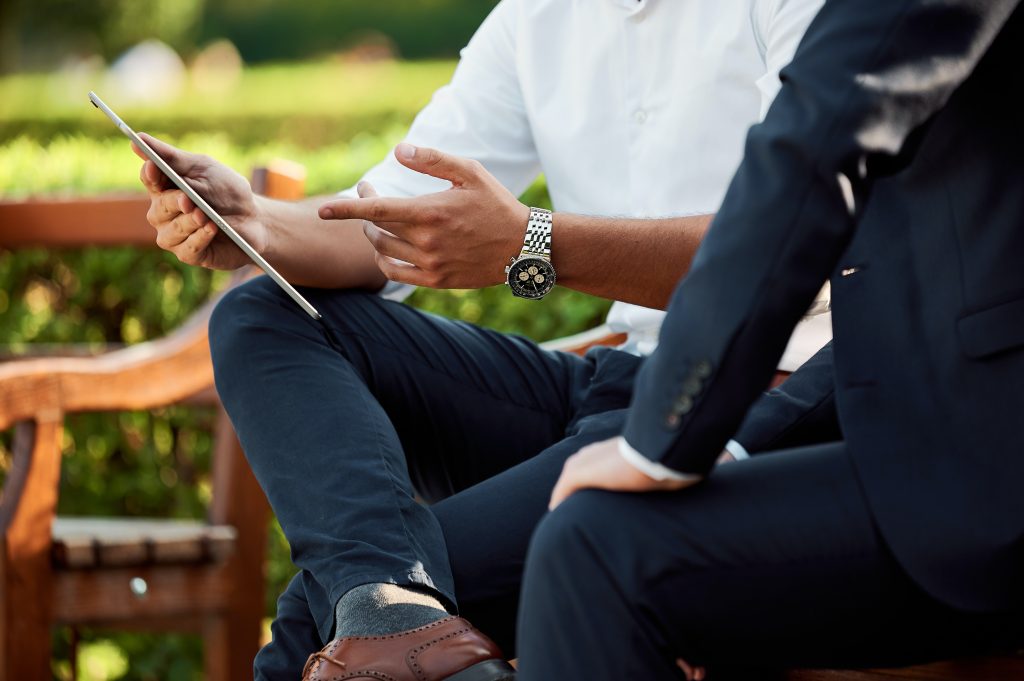 two men sitting on a bench having a meeting